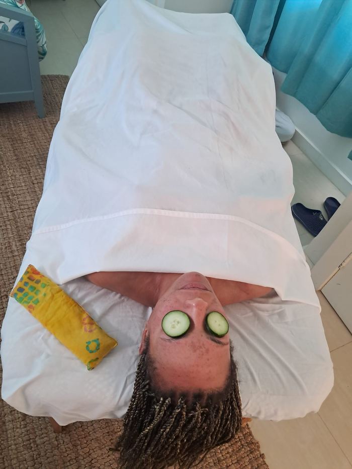 Client relaxing with cucumber slices over her eyes